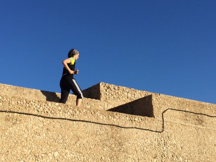 Frau rennt auf der Kaimauer